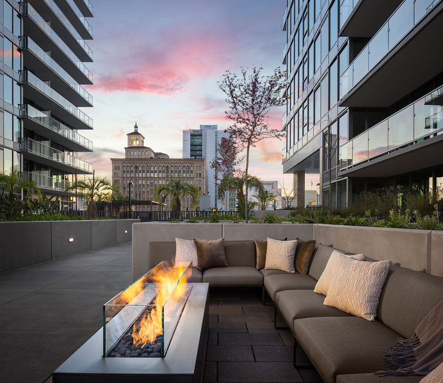 a fire pit on the roof of an apartment building in gaslamp downtown san diego california at sunset with fire pits and palm trees